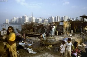 Shanty homes of fisher families and city immigrants on Back Bay, with tower blocks of Nariman Point in the background - Mumbai, India 2004. Credit: Paul Smith/Panos